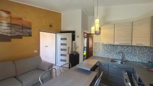 a kitchen and living room with a couch and a table at Casa Rita in San Teodoro