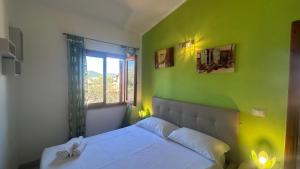 a bedroom with a green wall and a bed at Casa Rita in San Teodoro