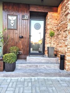 a front door of a house with stairs and plants at Mogosoaia High Living Studio in Chitila