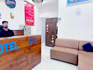 a man standing at a hotel lobby with a couch at Hotel JK in Hanumāngarh