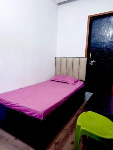 a small bed in a room with a pink mattress at Hotel JK in Hanumāngarh