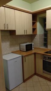 a kitchen with white cabinets and a microwave at Central Pécs Free Parking in Pécs