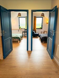 a room with two beds and an open door at Smugi Dom Gościnny in Lipowiec