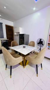 a dining room with a white table and chairs at The Jimi Stay in Maiyegun