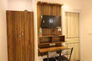 a room with a desk with a tv and a wooden cabinet at Aachman Restaurent in Bulandshahr
