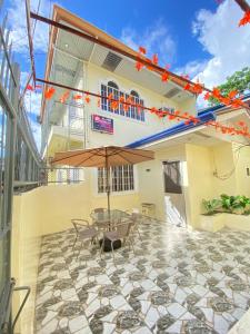a patio with a table and an umbrella at AJM Iligan Homestay in Saray