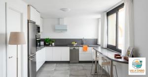 a white kitchen with white cabinets and a table at Villa Darío en Nazaret in Nazaret