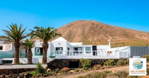 a house with palm trees in front of a mountain at Villa Darío en Nazaret in Nazaret