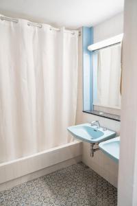 a bathroom with a white shower curtain and a sink at Hotel America Igualada in Igualada +26 photos