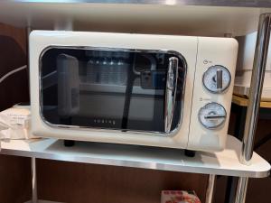 a white toaster oven sitting on a shelf at Sonoće Hostel Seoul - Private Bathroom & Premium in Seoul