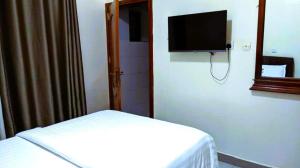 a bedroom with a bed and a flat screen tv at Bati Valley Guest House in Kigali