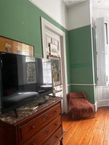 a living room with a flat screen tv on a dresser at Hotel Posada de 1860 in Tigre