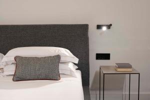 a bedroom with a bed and a table with a lamp at Habitat Boutique Hotel in Catania