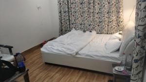 an unmade bed in a bedroom with a curtain at Gurez knights in Kanzalwan +6 photos