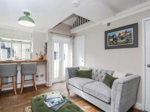 a living room with a couch and a table at Firefly Cottage in Cirencester