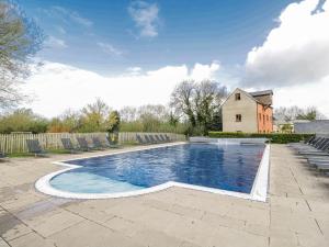 a swimming pool in a yard with a house at Firefly Cottage in Cirencester