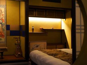 a bedroom with a bed and a light on a wall at 別邸 六花 in Hino