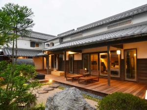 a house with a wooden deck in the yard at 別邸 六花 in Hino