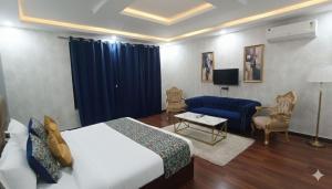 a hotel room with a bed and a blue couch at Hotel The Tark Near Delhi Airport in Champawat