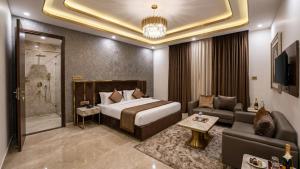 a hotel room with a bed and a couch at Hotel The Tark Near Delhi Airport in Champawat