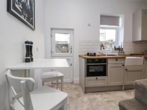 a kitchen with white cabinets and a counter top at 10 South Street in Rossendale