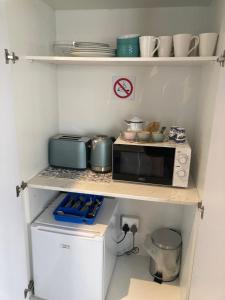 a small kitchen with a microwave and a stove at Shelley Cove in Stompneusbaai