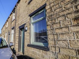 a window with blinds on a brick building at 10 South Street in Rossendale