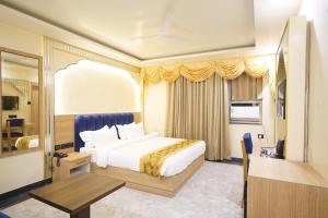 ein Schlafzimmer mit einem Kingsize-Bett und einem Tisch in der Unterkunft PS Marriott Hotel in Patna