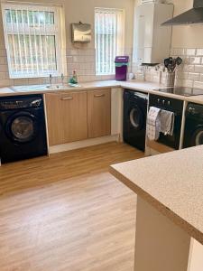 a kitchen with a washer and dryer at Spacious House Sleeps 10 -Near BikePark Wales -Central -Parking in Troed-y-rhiw