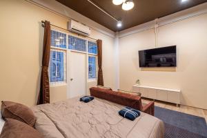 a bedroom with a bed and a flat screen tv at Queen On Street 2009 in Ban Lo Long