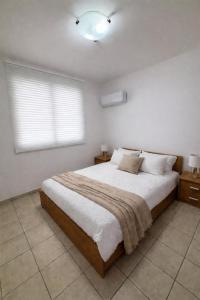 a bedroom with a large bed and a window at Seafront Escape Apartment in Oroklini