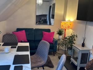 a living room with a green couch and pink pillows at 3 Linshader in Callernish