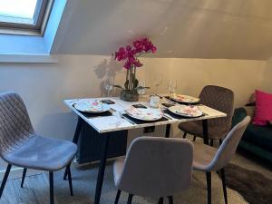 a table with chairs and plates and wine glasses at 3 Linshader in Callernish