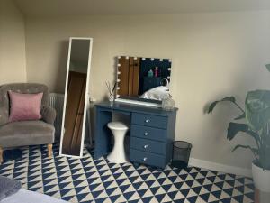 a room with a blue dresser and a mirror at 3 Linshader in Callernish