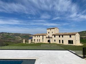 a large building on top of a hill with a sky at Agriturismo Il Borghetto in Montedinove