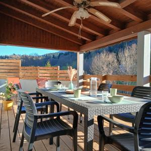 a patio table with chairs and a ceiling fan at La D'homette in Fresse-sur-Moselle