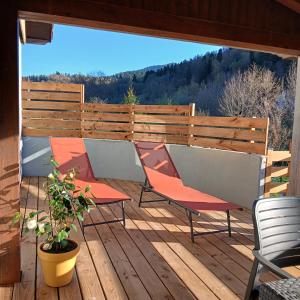 a deck with two chairs and a fence at La D'homette in Fresse-sur-Moselle