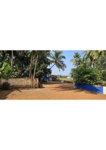 a dirt road with palm trees in the distance at Netrani Residency in Māvalli