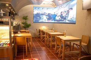 a restaurant with tables and chairs and a large screen at Quantum Hotel, Seoul Station br in Seoul