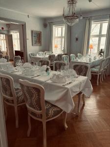 a large dining room with white tables and chairs at Munkedals Herrgård in Munkedal