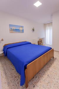 a bedroom with a large bed with a blue bedspread at Casaverde Gargano in Mattinata