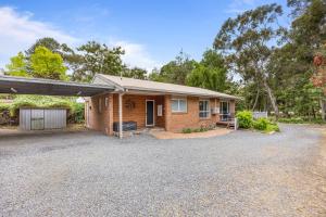 a brick house with a garage and a driveway at Kookaburra Retreat in Halls Gap