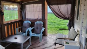 two chairs and a table on a screened in porch at L'échappée Verte in Chambellay