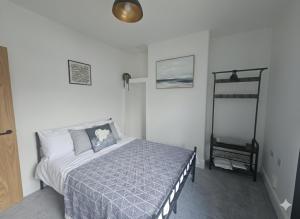 a bedroom with a bed with a blue comforter at The Quay Corner in Saint Thomas Station