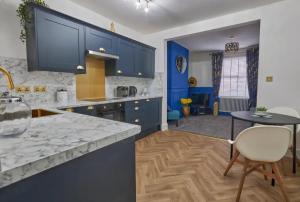 a large kitchen with blue cabinets and a table at The Quay Corner in Saint Thomas Station
