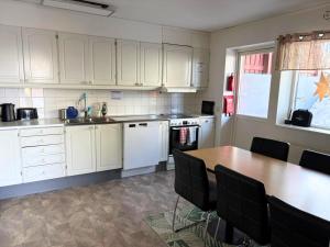 a kitchen with white cabinets and a wooden table at Abisko Hostel in Abisko