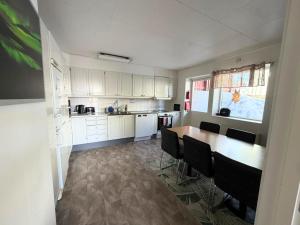 a kitchen with white cabinets and a table and chairs at Abisko Hostel in Abisko +13 photos