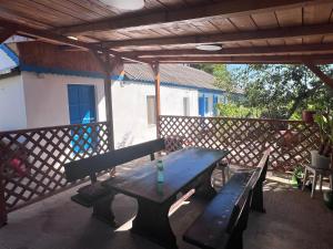 a picnic table with two benches on a patio at Casa Albastra in Mahmudia
