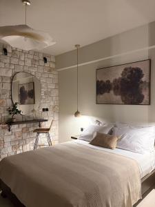 a bedroom with a large bed and a stone wall at Noima Kalamitsi Boutique Studios in Kalamitsi