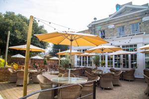 an outdoor patio with tables and chairs and umbrellas at The Chalk Hare, Royston, Hertfordshire - Acorn Pubs in Royston